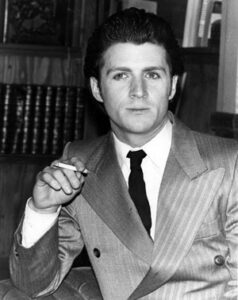 A Person in a Suit Holding a Cigarette